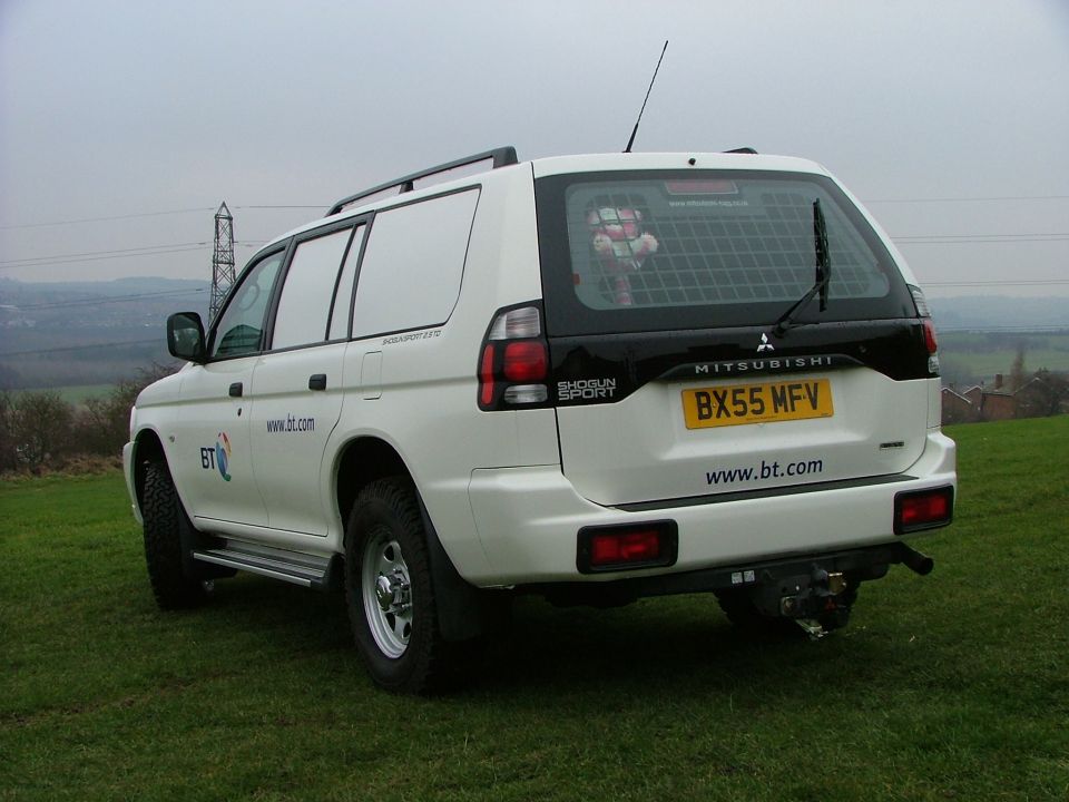 White BT-liveried Mitsubishi Shogun Sport SUV, rear view on grass