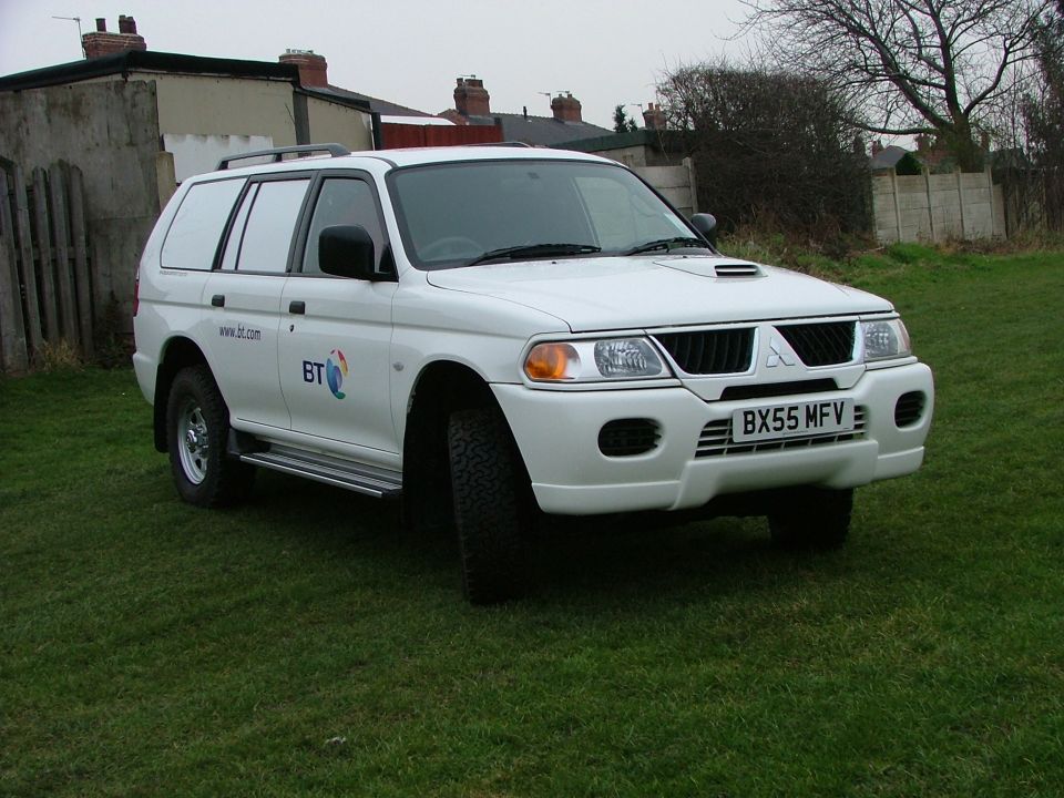 White Mitsubishi 4x4 wagon in BT fleet livery parked on grass, UK plate BX55 MFV