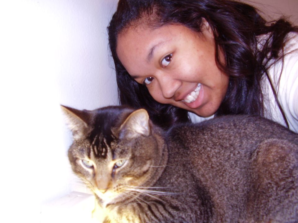 woman smiling with her cat in front of her