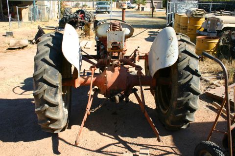 1981 Ford F-150 - A vintage tractor sits in a yard with other vehicles and equipment.