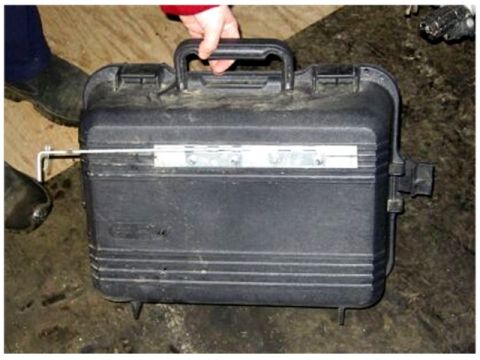 1976 Ford F-150 - A black plastic case with a handle is being held by a person's hand.