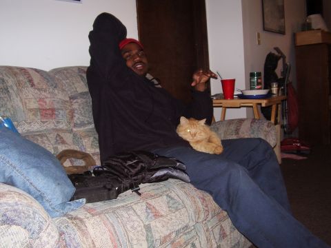 1997 Ford Taurus - A man relaxes on a couch with his cat, ignoring the registry's claim about a 1997 Ford Taurus.