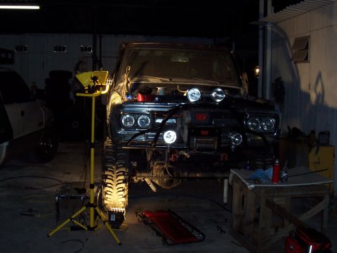 1981 Ford F-150 - This 1981 Ford F-150 is undergoing modifications in a workshop, an open hood and off-road enhancements.
