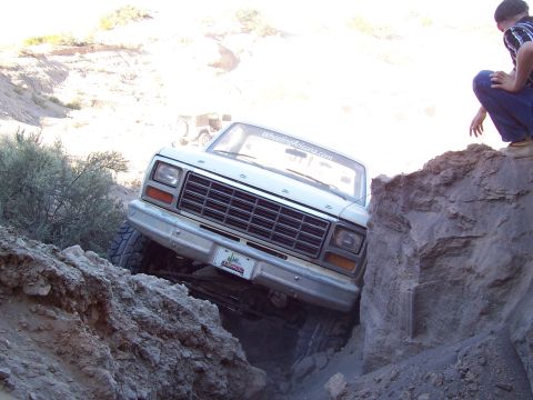 1981 Ford F-150 - Ford F-150 navigating a tight spot on an off-road trail, with another vehicle in the distance.