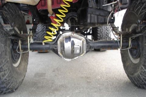 1987 Suzuki Samurai - Close-up of a vehicle's rear axle assembly, showing suspension and differential cover.