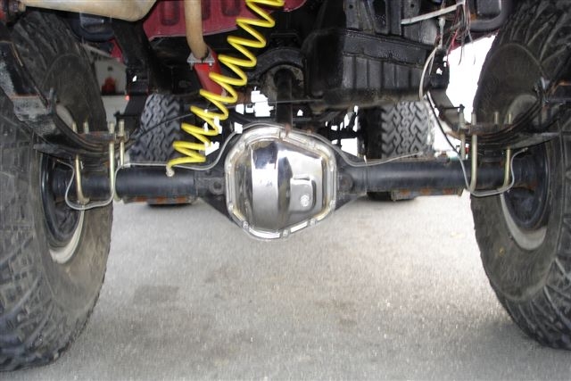Rear axle housing with chrome cover, leaf springs, and yellow shock absorber