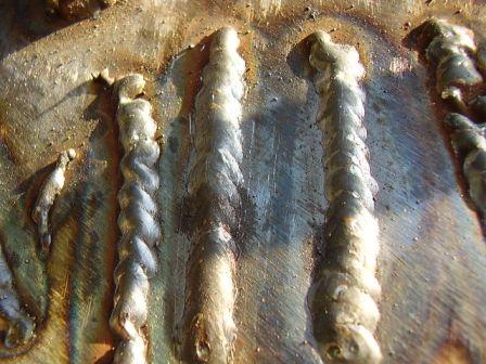 2004 Aston Martin Virage - The photo shows multiple parallel welds on a metallic surface, with varying textures and some discoloration.