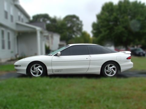 1996 Ford Probe - Side view of a white 1996 Ford Probe GT coupe parked on a lawn.