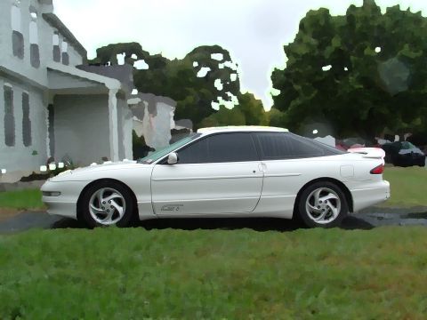 1996 Ford Probe - A white 1996 Ford Probe GT is parked on a grassy lawn next to a house.
