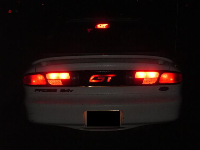 White 1996 Ford Probe GT rear with illuminated taillights and GT badge