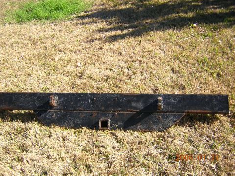 1986 Chevrolet Blazer - This black trailer hitch receiver is shown lying on dry grass. It features a square opening and two mounting brackets.