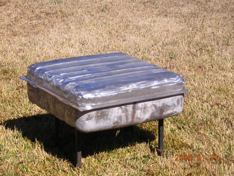 1986 Chevrolet Blazer - Fuel tank with ribbed top, supported by legs on a grassy area.
