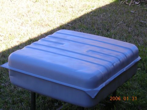 1986 Chevrolet Blazer - A gray plastic fuel tank with a ribbed top is shown outdoors, resting on a stand.