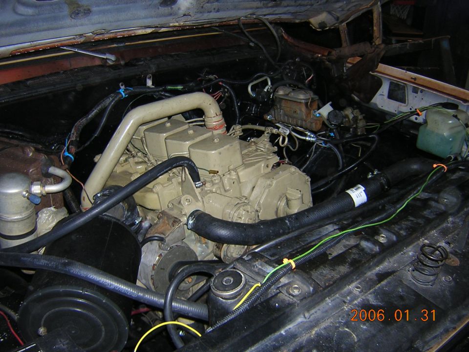 Engine bay with a tan diesel engine, hoses, and wiring. Date stamp reads 2006.01.31
