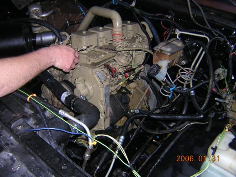 1986 Chevrolet Blazer - A hand is seen working on the engine in the engine bay. The image has a date stamp of 2006.01.31.