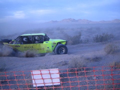 Green Weger Mortgage off-road buggy on desert trail with mountains behind