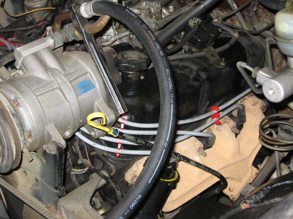 Engine bay close-up of A/C compressor, heater hoses, and wiring with timing marks circled in red
