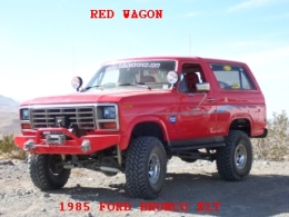 1985 Ford Bronco - This red 1985 Ford Bronco features off-road tires, a winch, and custom bumpers, indicating it's built for terrain.