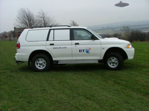 1979 Ford Ranchero - Side view of a white panel van SUV with BT branding and a website address on its doors.