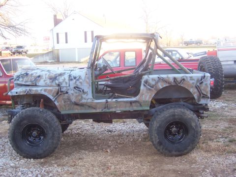 1992 Ford C-250 (Centurion Conversions) - Modified Jeep CJ-series with camouflage paint and roll cage, parked outdoors.