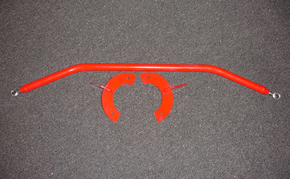 Red strut tower brace with two red mounting brackets attached by zip ties