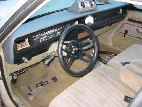 1985 Ford Crown Victoria LTD - The interior features an aftermarket steering wheel and additional gauges mounted on the dashboard, alongside the original instrument clust…