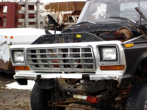 1979 Ford Bronco - The front end of a 1979 Ford Bronco is shown with its hood open, revealing the engine compartment.