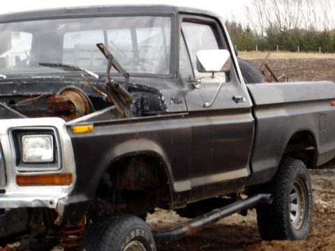 1979 Ford Bronco - This Ford pickup truck, likely from the 1970s, is shown from the front quarter with its hood open and modified suspension.