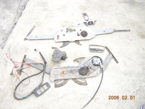 1986 Chevrolet Blazer - Several car window regulators and related components are displayed on a concrete surface.