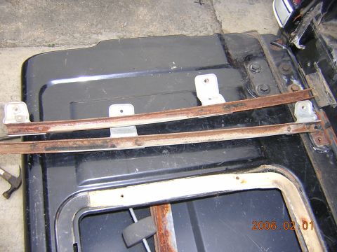 1986 Chevrolet Blazer - The photo shows rusty window regulator tracks and mounting hardware, likely from a vehicle's door or tailgate.