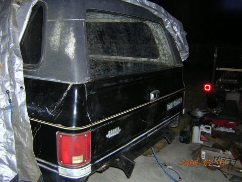 1986 Chevrolet Blazer - Rear view of a black SUV with a camper shell, showing the 'Cheyenne' badging.