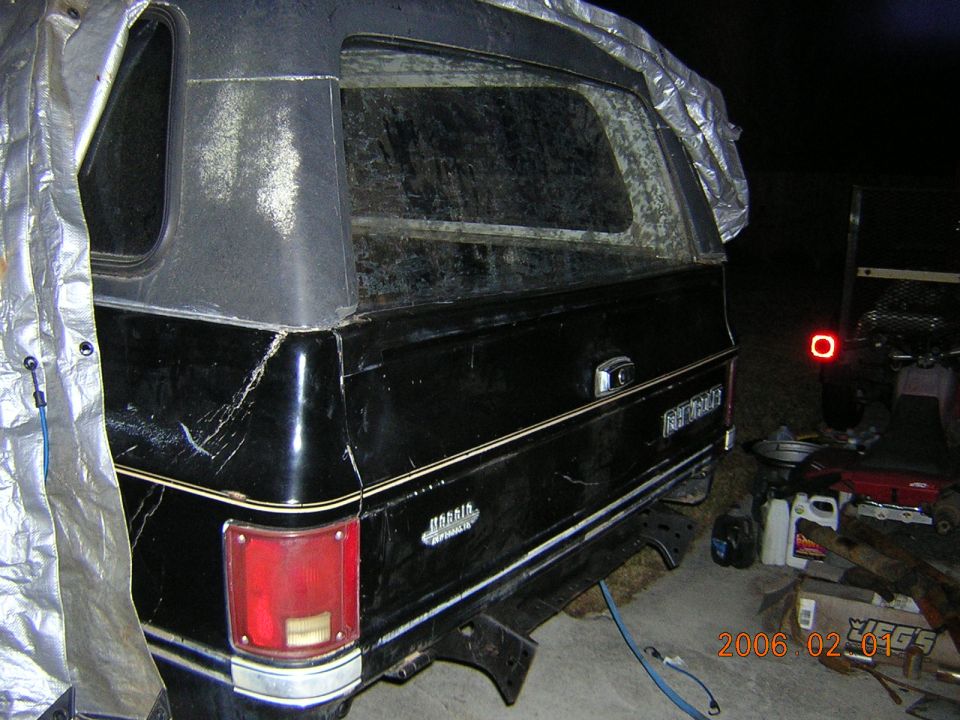 Black SUV with camper shell, rear view. Visible text reads 'Cheyenne'