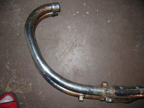 1985 Ford LTD Crown Victoria - A motorcycle exhaust pipe is shown, with visible signs of wear and tear.