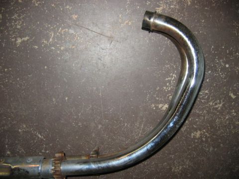 1985 Ford LTD Crown Victoria - A single chrome exhaust pipe is shown against a textured background.