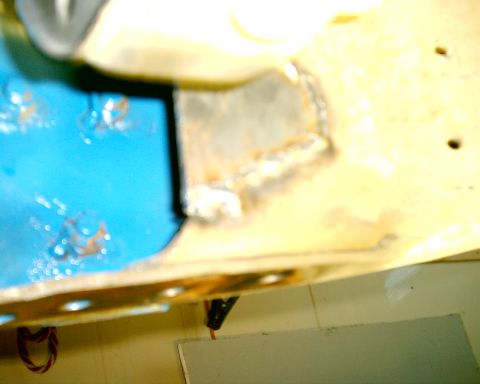 1985 Ford Bronco - Close-up of a welded metal frame section, possibly from a vehicle chassis, with blue paint visible.