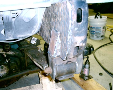 1985 Ford Bronco - Close-up of a welded metal bracket on a vehicle frame, with a jack visible.