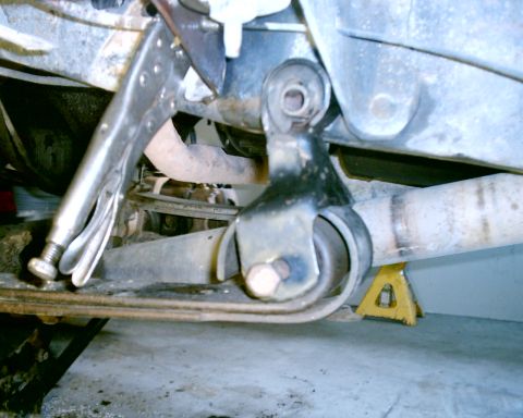 1985 Ford Bronco - A close-up view of a vehicle's undercarriage, showing a suspension part secured with vise grips.
