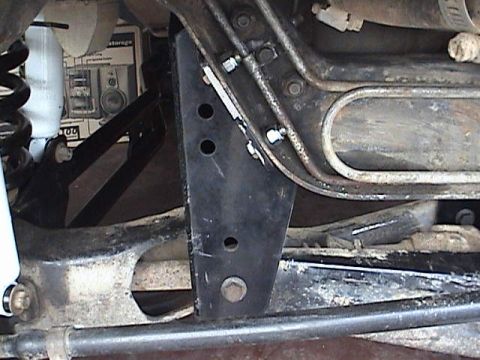 1994 Ford Bronco - Close-up view of vehicle suspension components, including a shock absorber and metal brackets.