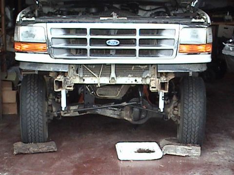 1994 Ford Bronco - Front view of a Ford truck undergoing modifications, with the bumper removed and suspension components visible.