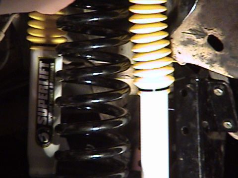 1994 Ford Bronco - Close-up of suspension components, including a SUPERLIFT shock absorber and coil springs.