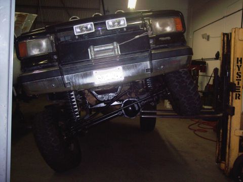 1988 Ford Bronco - 1988 Ford Bronco front view, lifted on a hoist with a winch mounted to the bumper.