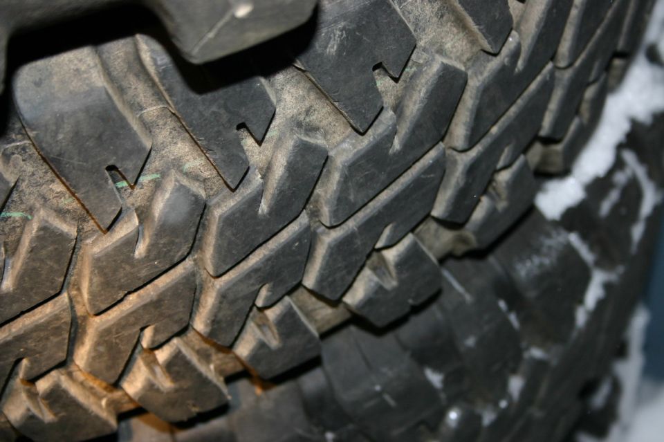 Close-up of a tire tread with some snow on the side