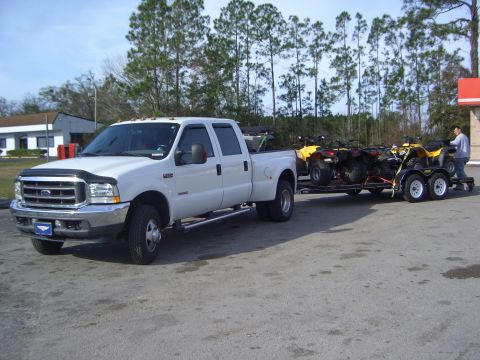 1996 Ford Bronco - A white 2005 Ford F-350 Super Duty truck is seen from the front-right, towing a trailer loaded with four ATVs.
