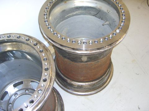 1996 Ford Bronco - Two custom rims are shown, one with a polished lip and a barrel showing significant rust.