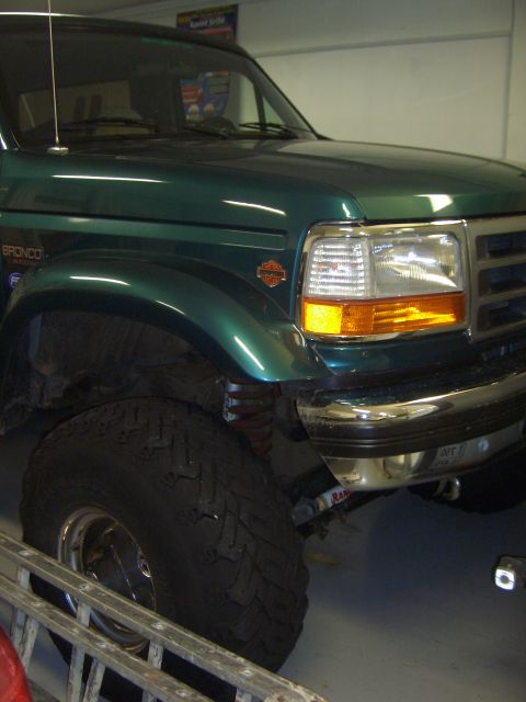 1996 Ford Bronco - A green Ford Bronco is shown from the front quarter angle, highlighting its large tire and chrome accents.