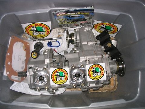 1986 Ford F-150 - A close-up of a Toyota transfer case, likely for an off-road vehicle, with promotional stickers and a magazine.