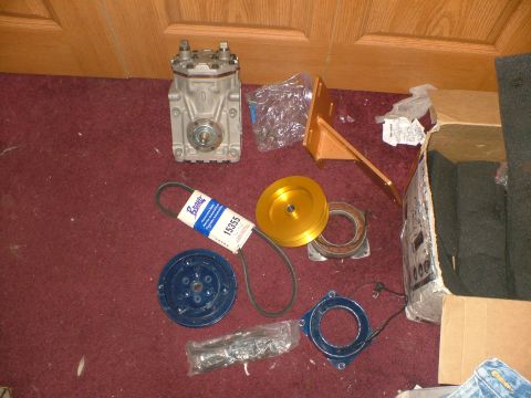 1989 Ford Bronco - Various parts for an air conditioning system are laid out on a carpeted floor.