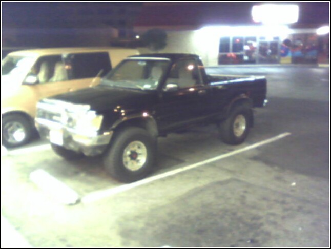 Black pickup truck parked next to a van
