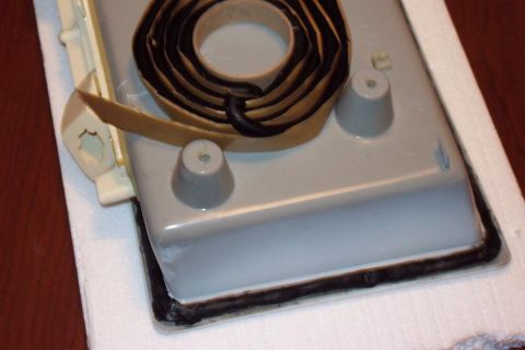 1985 Ford Crown Victoria LTD - A part is shown with sealant tape and gasket material applied around its edge.