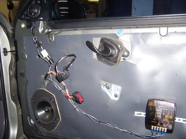 Interior of a car door with trim panel removed showing speaker and wiring